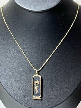 Gold-toned Egyptian cartouche pendant necklace featuring raised hieroglyphic